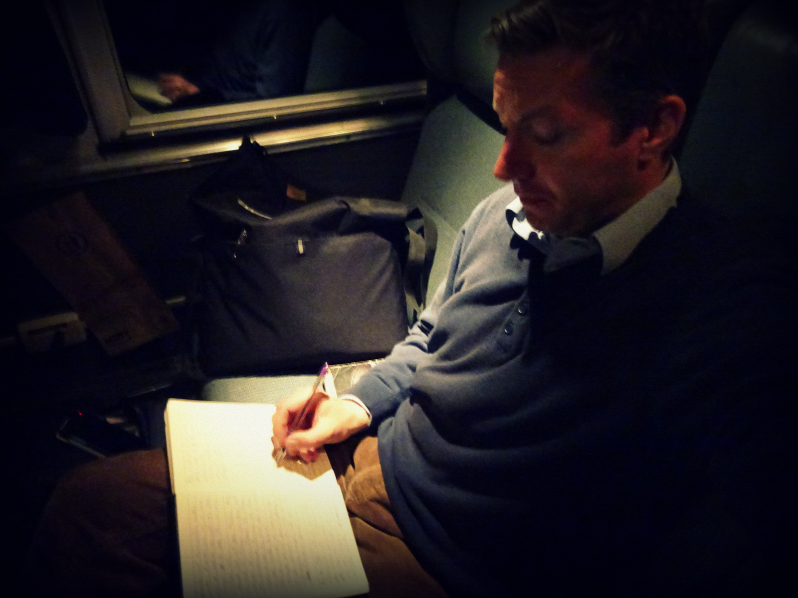 Andreas Moser writing on the train